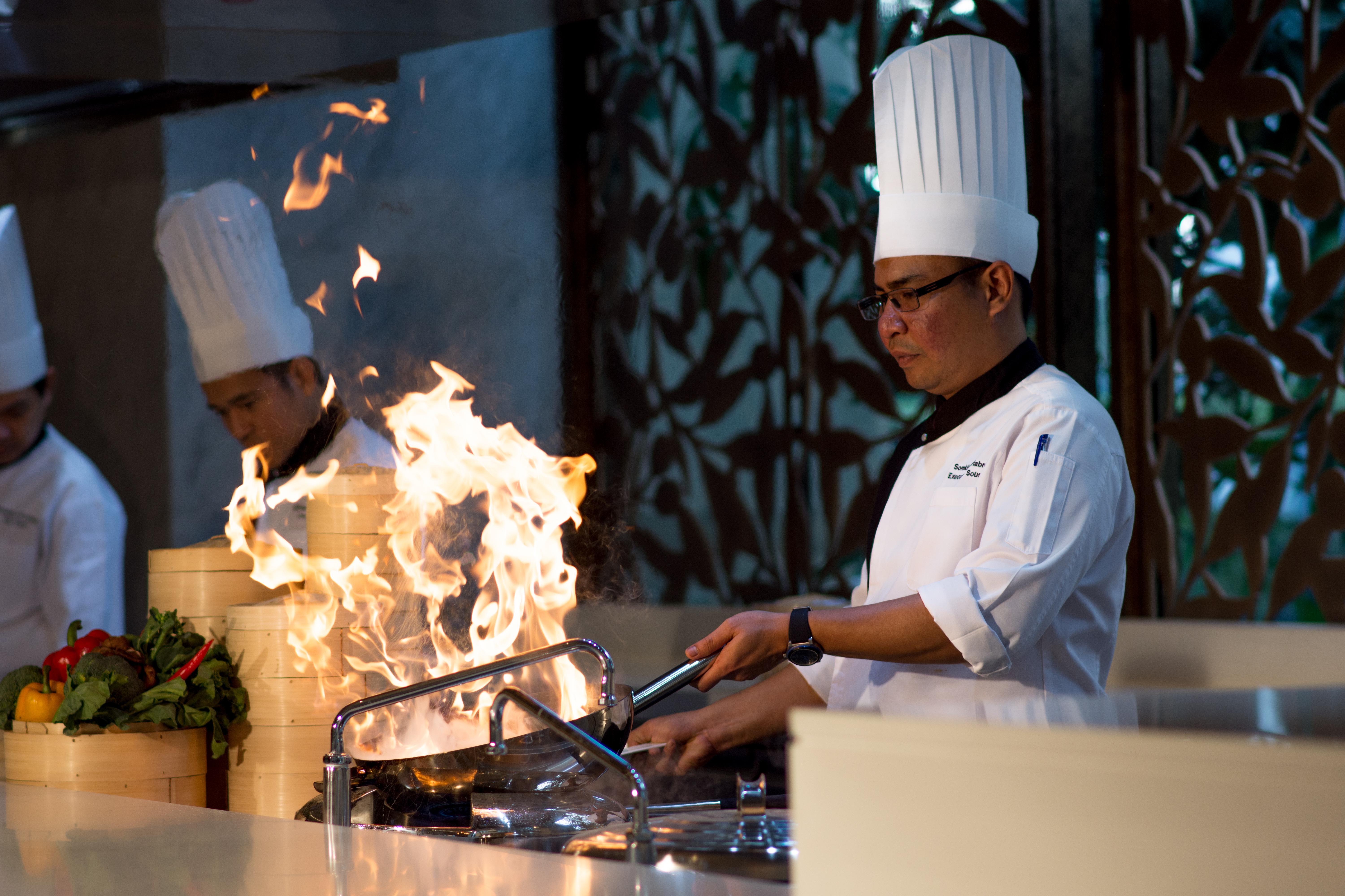 Lancaster Bangkok Hotel Eksteriør billede A chef cooking with a wok